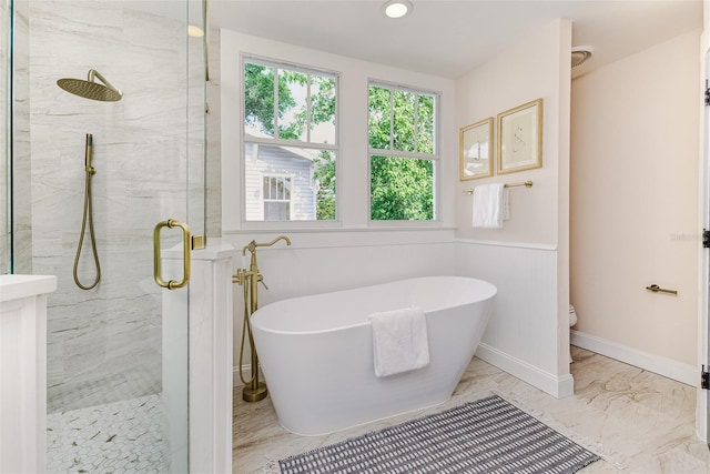 746 Mississippi Ave, Lakeland, FL 33801 - bathroom featuring a freestanding tub, toilet, a stall shower, a wainscoted wall, and marble finish floor