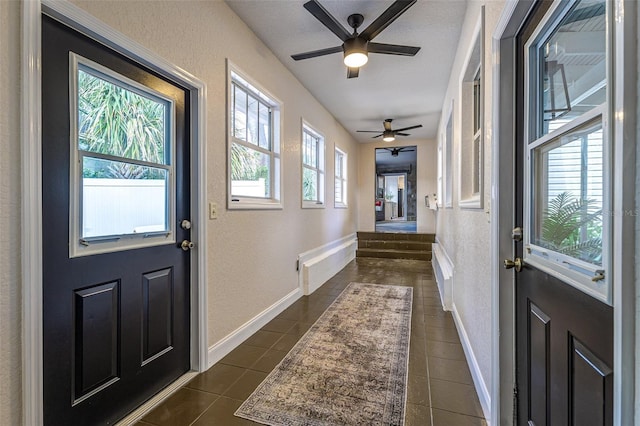 746 Mississippi Ave, Lakeland, FL 33801 - doorway featuring dark tile patterned floors, baseboards, a ceiling fan, and a textured wall