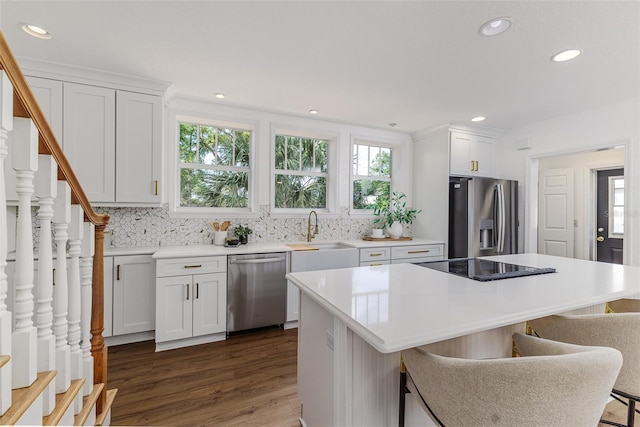 746 Mississippi Ave, Lakeland, FL 33801 - kitchen featuring a sink, a kitchen breakfast bar, dark wood-type flooring, backsplash, and appliances with stainless steel finishes