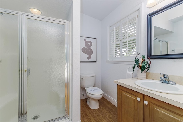 746 Mississippi Ave, Lakeland, FL 33801 - bathroom featuring vanity, toilet, a stall shower, baseboards, and wood finished floors