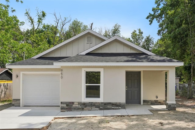 view of front of home with roof with shingles, board and batten siding, driveway, and a garage