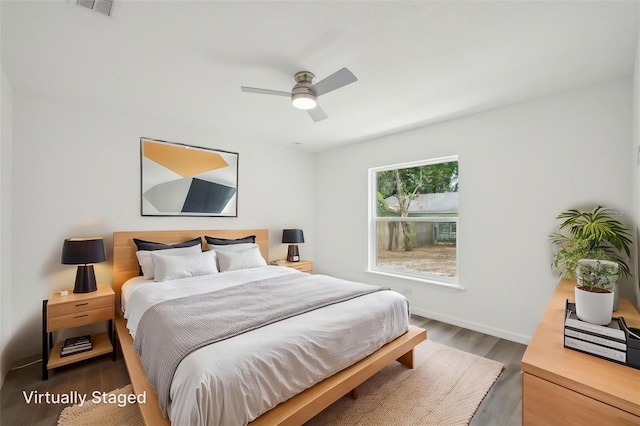 bedroom with baseboards, ceiling fan, wood finished floors, and visible vents