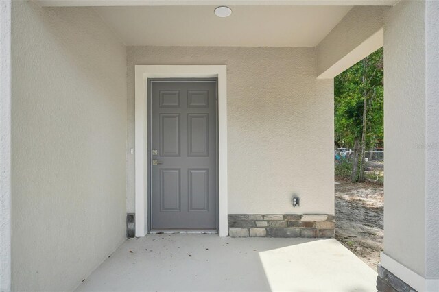 doorway to property featuring stucco siding