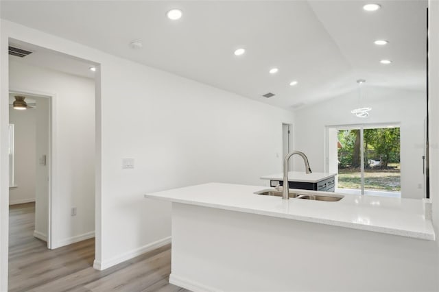 kitchen featuring a sink, light wood-style flooring, recessed lighting, vaulted ceiling, and visible vents