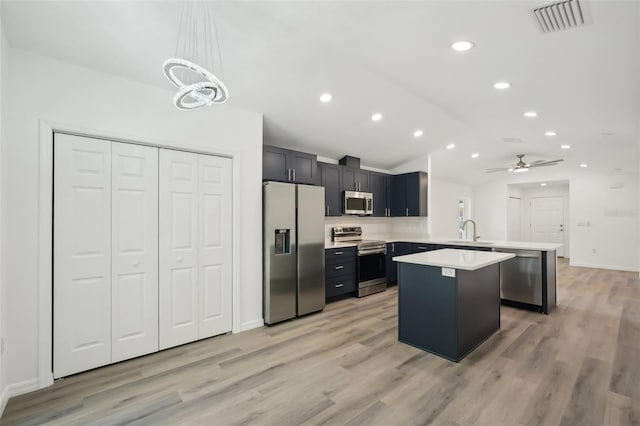 kitchen featuring visible vents, appliances with stainless steel finishes, a sink, light countertops, and a peninsula