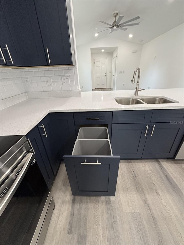 kitchen featuring light wood-type flooring, a sink, stainless steel electric range, and backsplash