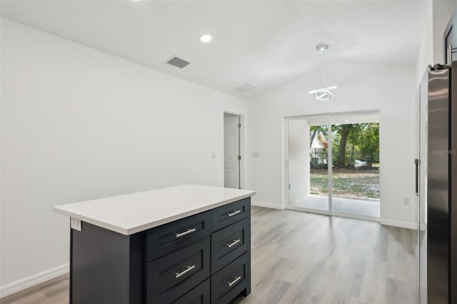 kitchen featuring light wood-style floors, light countertops, baseboards, lofted ceiling, and visible vents