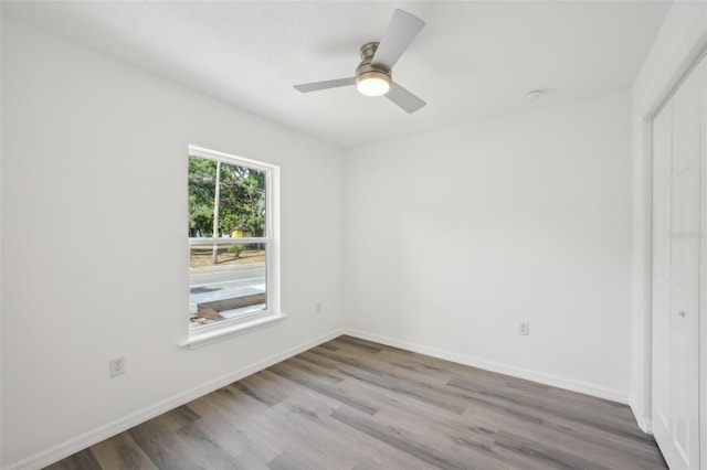 unfurnished room featuring baseboards, a ceiling fan, and wood finished floors