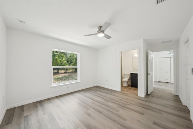 unfurnished bedroom with ceiling fan, visible vents, baseboards, light wood finished floors, and connected bathroom
