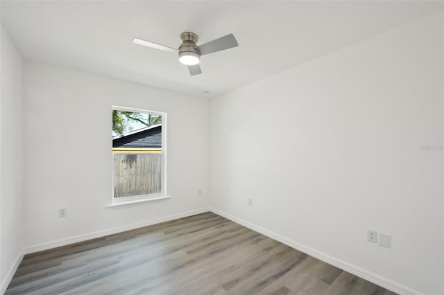 empty room with baseboards, a ceiling fan, and wood finished floors
