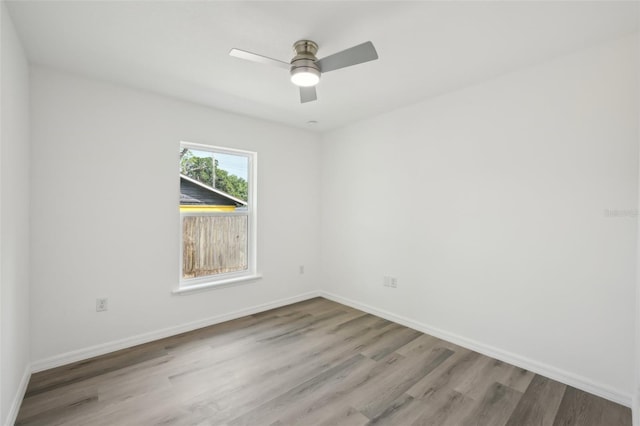 spare room featuring baseboards, a ceiling fan, and wood finished floors