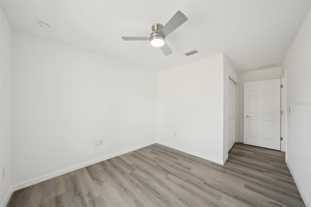 unfurnished bedroom featuring visible vents, baseboards, ceiling fan, and wood finished floors