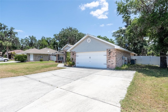 2933 Blackwater Oaks Dr, Mulberry, FL 33860 - ranch-style home with concrete driveway, fence, a front lawn, brick siding, and a garage