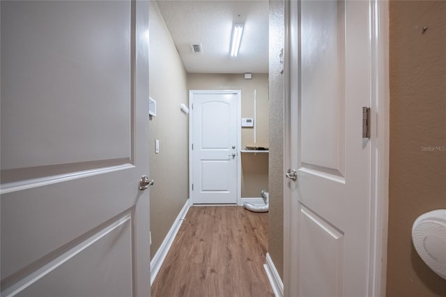 2933 Blackwater Oaks Dr, Mulberry, FL 33860 - hallway featuring baseboards, light wood-type flooring, and visible vents