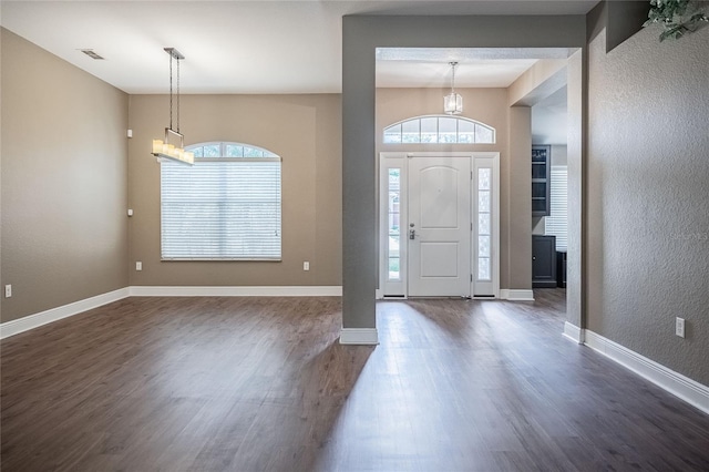 2933 Blackwater Oaks Dr, Mulberry, FL 33860 - foyer entrance featuring a chandelier, dark wood-type flooring, visible vents, a textured wall, and baseboards