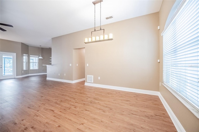 2933 Blackwater Oaks Dr, Mulberry, FL 33860 - empty room featuring baseboards, visible vents, ceiling fan with notable chandelier, and light wood-style flooring