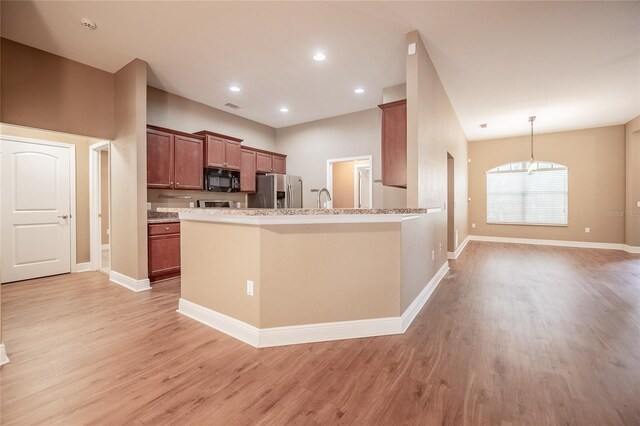 2933 Blackwater Oaks Dr, Mulberry, FL 33860 - kitchen with black microwave, a chandelier, baseboards, light wood-type flooring, and stainless steel fridge with ice dispenser