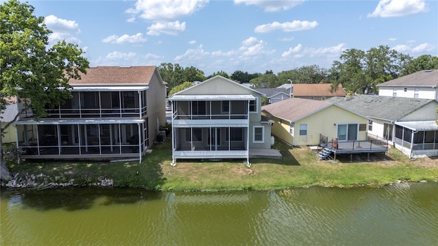 back of property featuring a sunroom, a water view, a yard, and a residential view