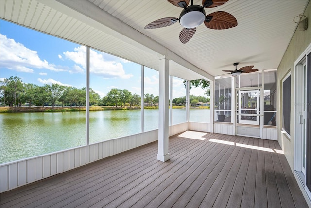 unfurnished sunroom with a water view, plenty of natural light, and a ceiling fan