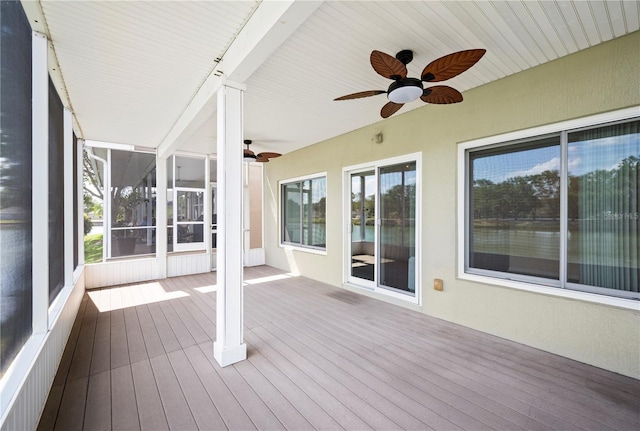 unfurnished sunroom with a ceiling fan and a healthy amount of sunlight