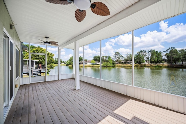 unfurnished sunroom with a ceiling fan, a wealth of natural light, and a water view