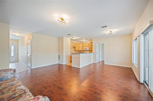 unfurnished living room featuring baseboards, light wood-style flooring, and visible vents