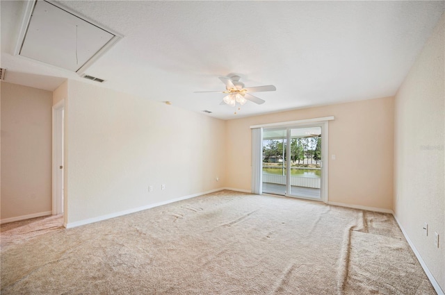 spare room with carpet floors, ceiling fan, attic access, and visible vents