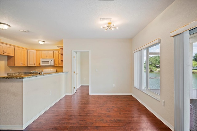 kitchen with dark wood-style flooring, open shelves, stove, white microwave, and a chandelier