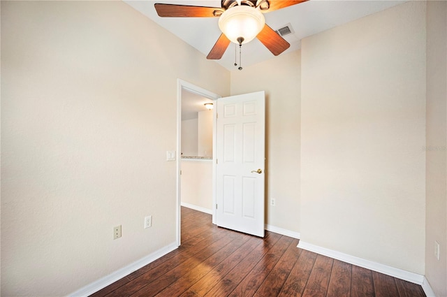 unfurnished bedroom featuring baseboards, dark wood-type flooring, visible vents, and ceiling fan