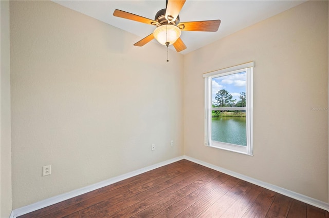 empty room featuring baseboards, ceiling fan, and dark wood-type flooring