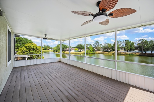 unfurnished sunroom with a ceiling fan and a water view