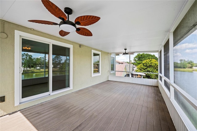 unfurnished sunroom featuring a water view and ceiling fan