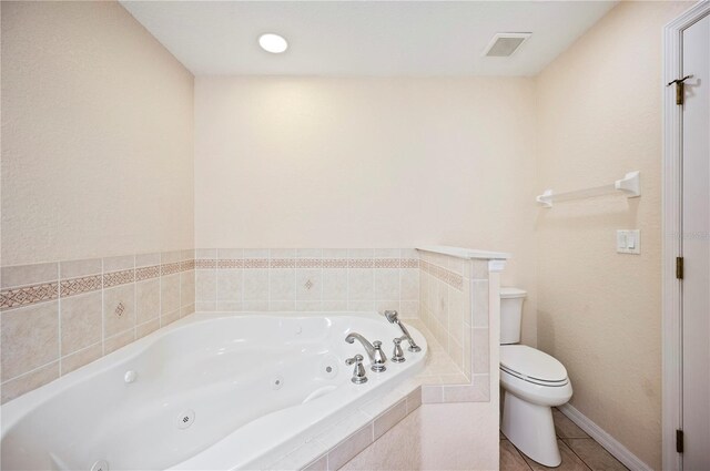 bathroom featuring visible vents, tile patterned flooring, toilet, and a jetted tub