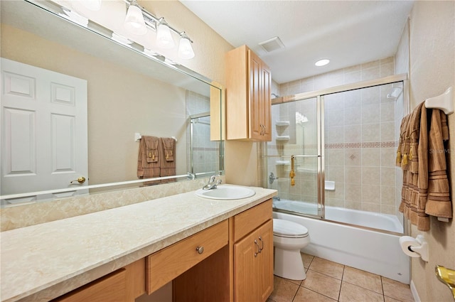 full bath with visible vents, tile patterned floors, vanity, combined bath / shower with glass door, and toilet