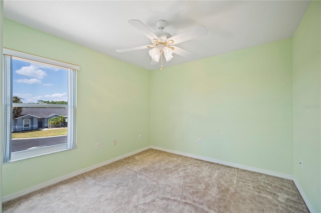 spare room featuring carpet floors, baseboards, and ceiling fan