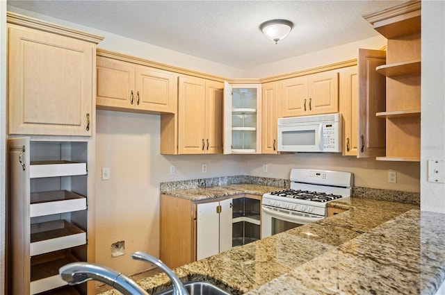 kitchen featuring light brown cabinets, open shelves, and white appliances