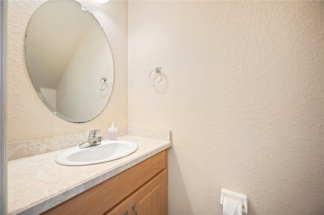 bathroom with vanity and a textured wall
