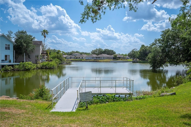 view of dock with a yard, a water view, and a residential view