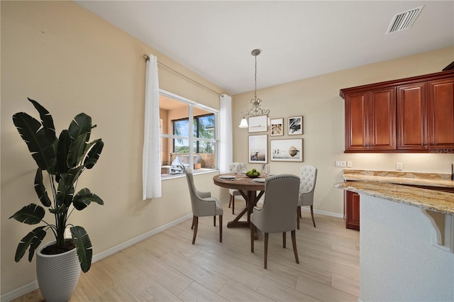 dining room with visible vents, baseboards, and light wood-style floors