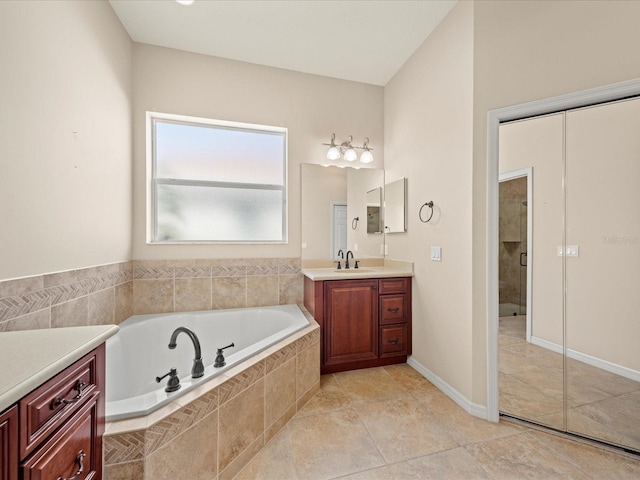 bathroom featuring a stall shower, a bath, and vanity