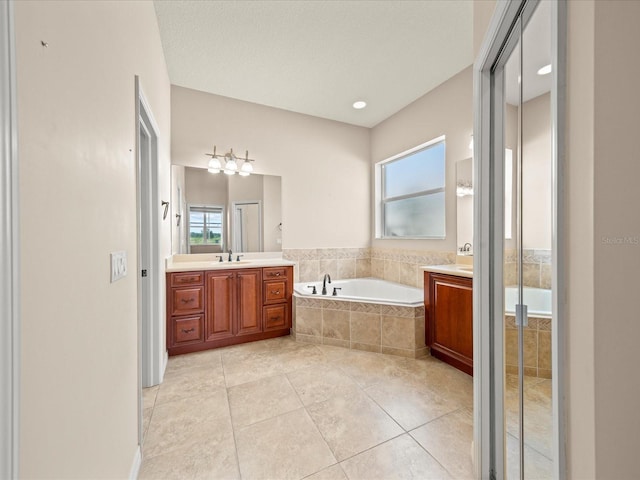 bathroom with tile patterned floors, a garden tub, vanity, and plenty of natural light