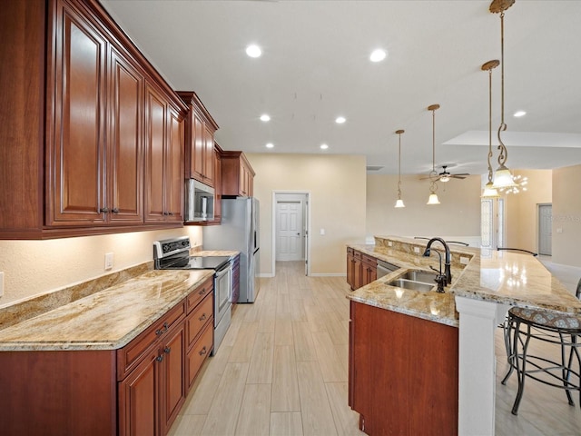 kitchen featuring recessed lighting, a sink, ceiling fan, a breakfast bar, and appliances with stainless steel finishes