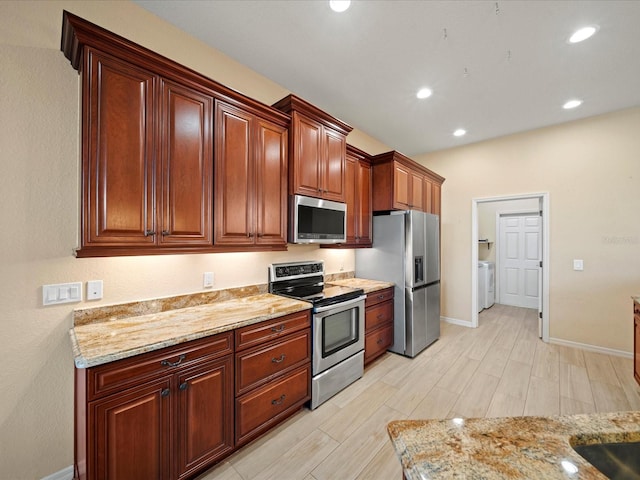 kitchen featuring recessed lighting, light wood-style floors, appliances with stainless steel finishes, baseboards, and washer / clothes dryer