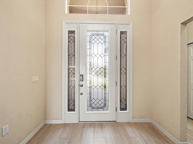 foyer entrance featuring baseboards and wood finished floors