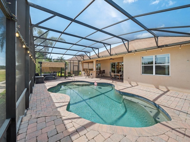 pool featuring a patio, a hot tub, a ceiling fan, outdoor dining space, and a lanai