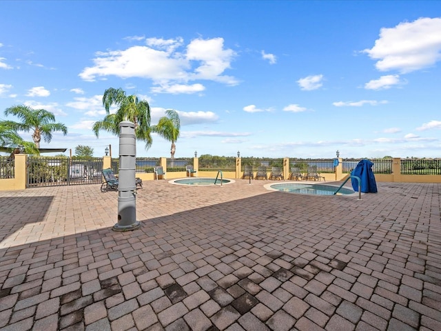 exterior space featuring fence, a swimming pool, a patio area, and a jacuzzi