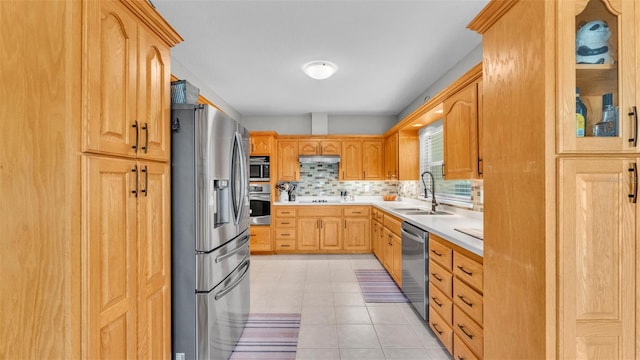 kitchen featuring backsplash, a sink, light countertops, stainless steel appliances, and light tile patterned flooring