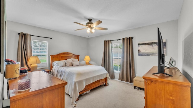bedroom featuring multiple windows, light carpet, and ceiling fan