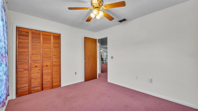 unfurnished bedroom featuring visible vents, a closet, baseboards, a textured ceiling, and carpet