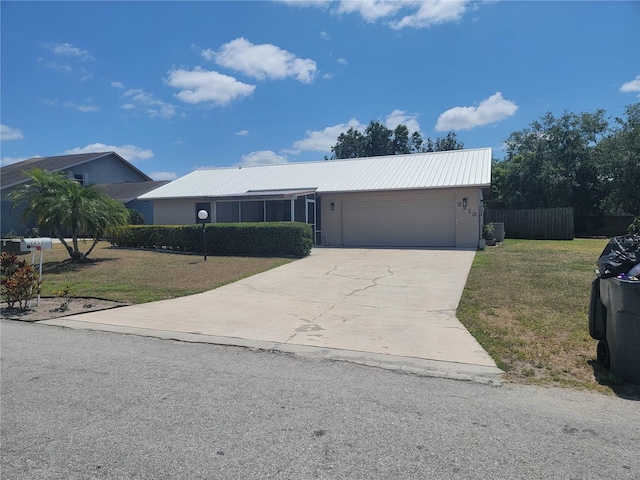 ranch-style house with concrete driveway, a garage, fence, and a front lawn
